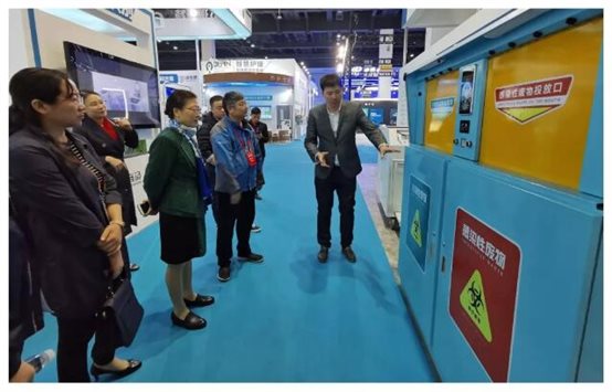 2019全国医院物联网大会的工作人员向医院领导介绍医废方案